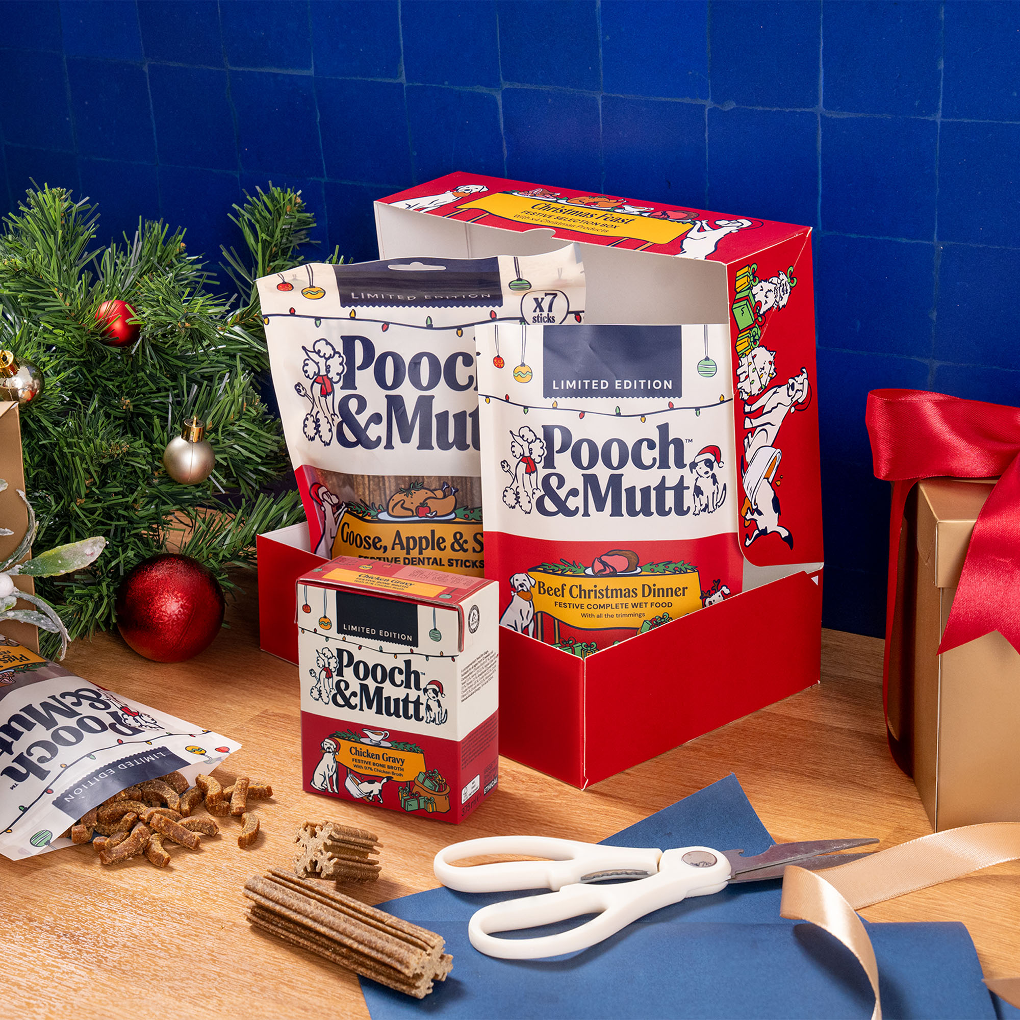 Image of Pooch & Mutt Christmas gift box for 2026. Shows the contents of the box open on a kitchen counter with blue tiles and Christmas props