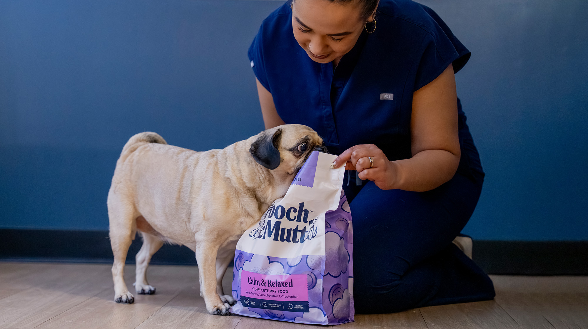 Image of Dr Bushra Schuitemaker with a Pug and a bag of Calm & Relaxed Dry Food