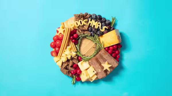 A pooch inspired cheeseboard with dog meat, dental sticks, and other treats, alongside cheese spelling out "Poochmas"