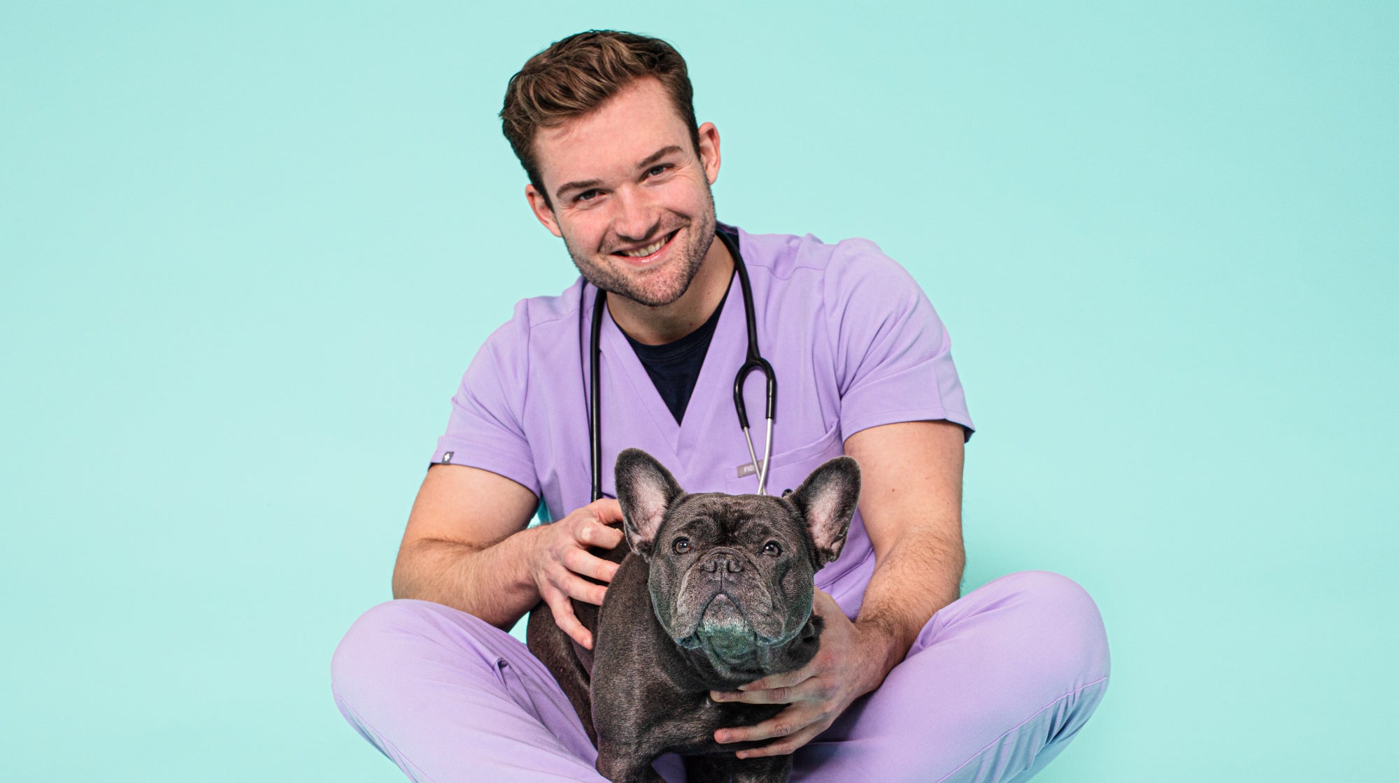 Vet Alex with a french bulldog on a blue background