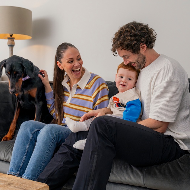 Family sitting on a sofa with a dog