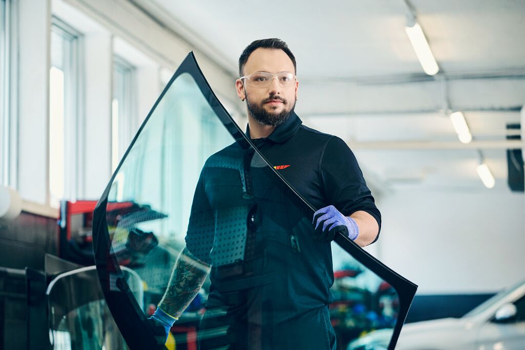 Man carrying a windshield