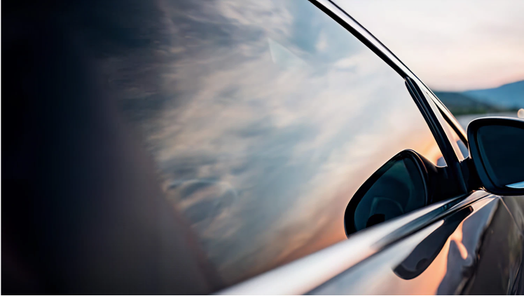 Image of a car side window reflecting the sunset