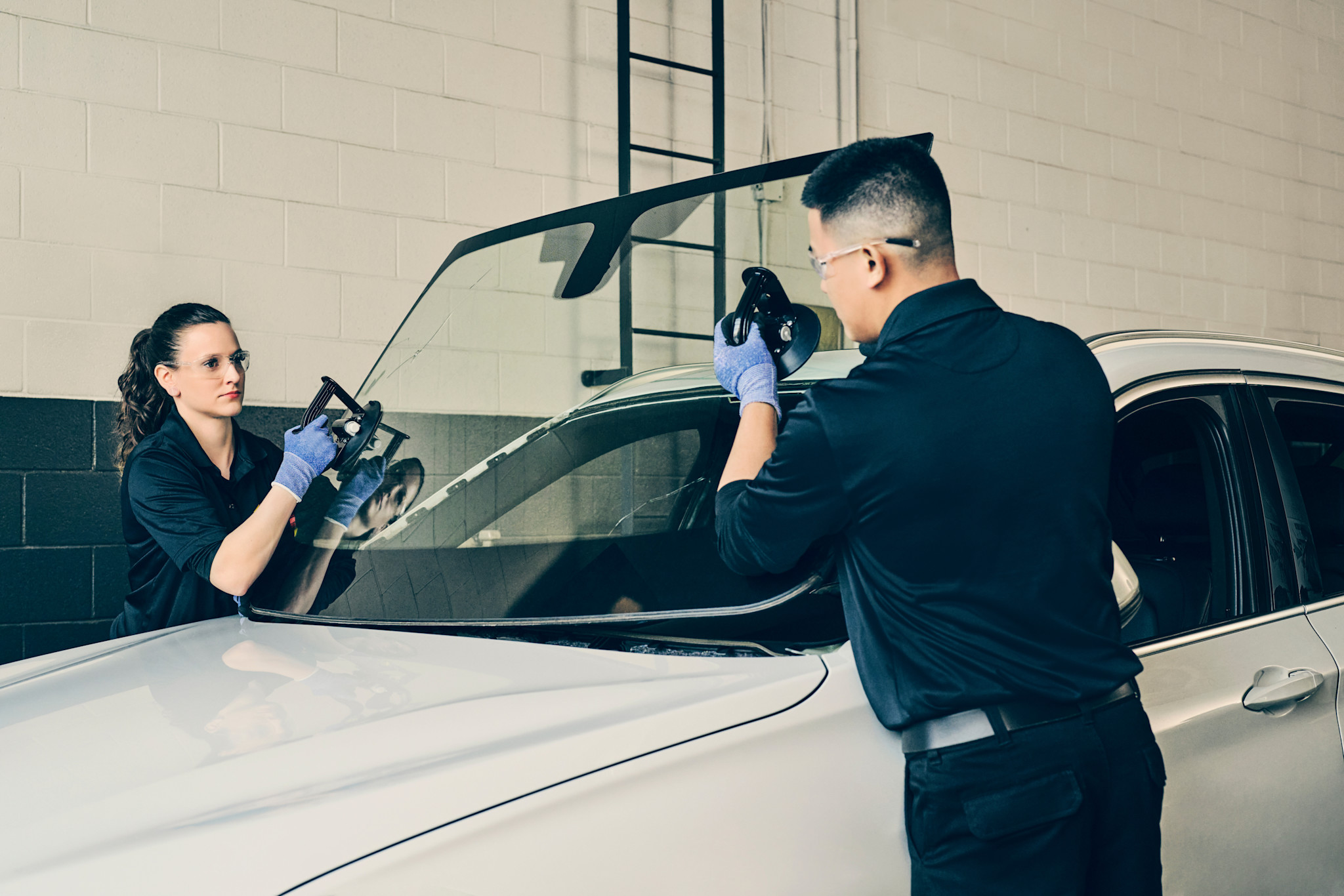 Deux techniciens remplacant un pare brise