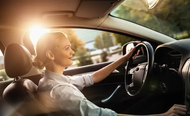 Vue de côté d'une femme conduisant une voiture