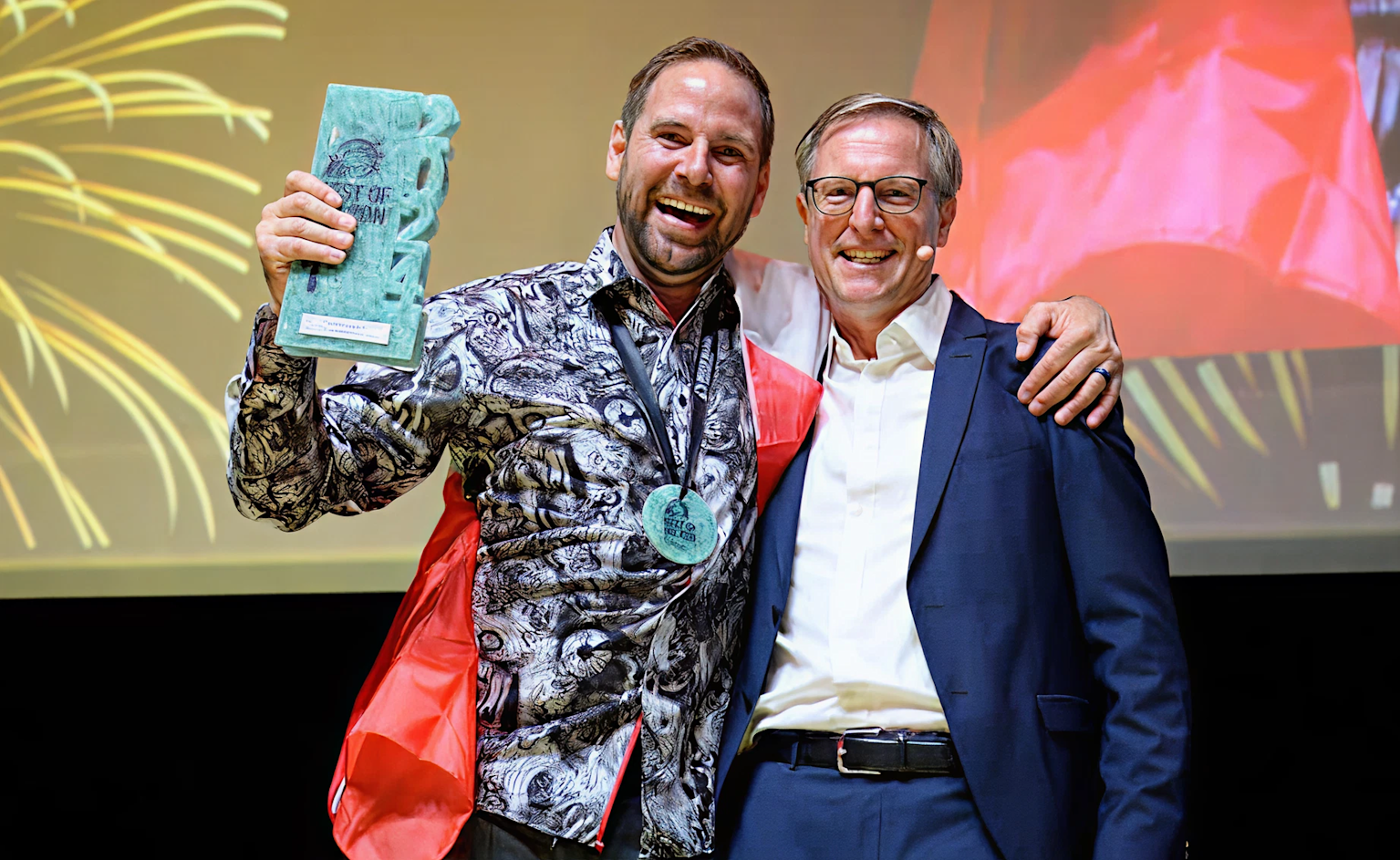 Two men celebrating receiving an award