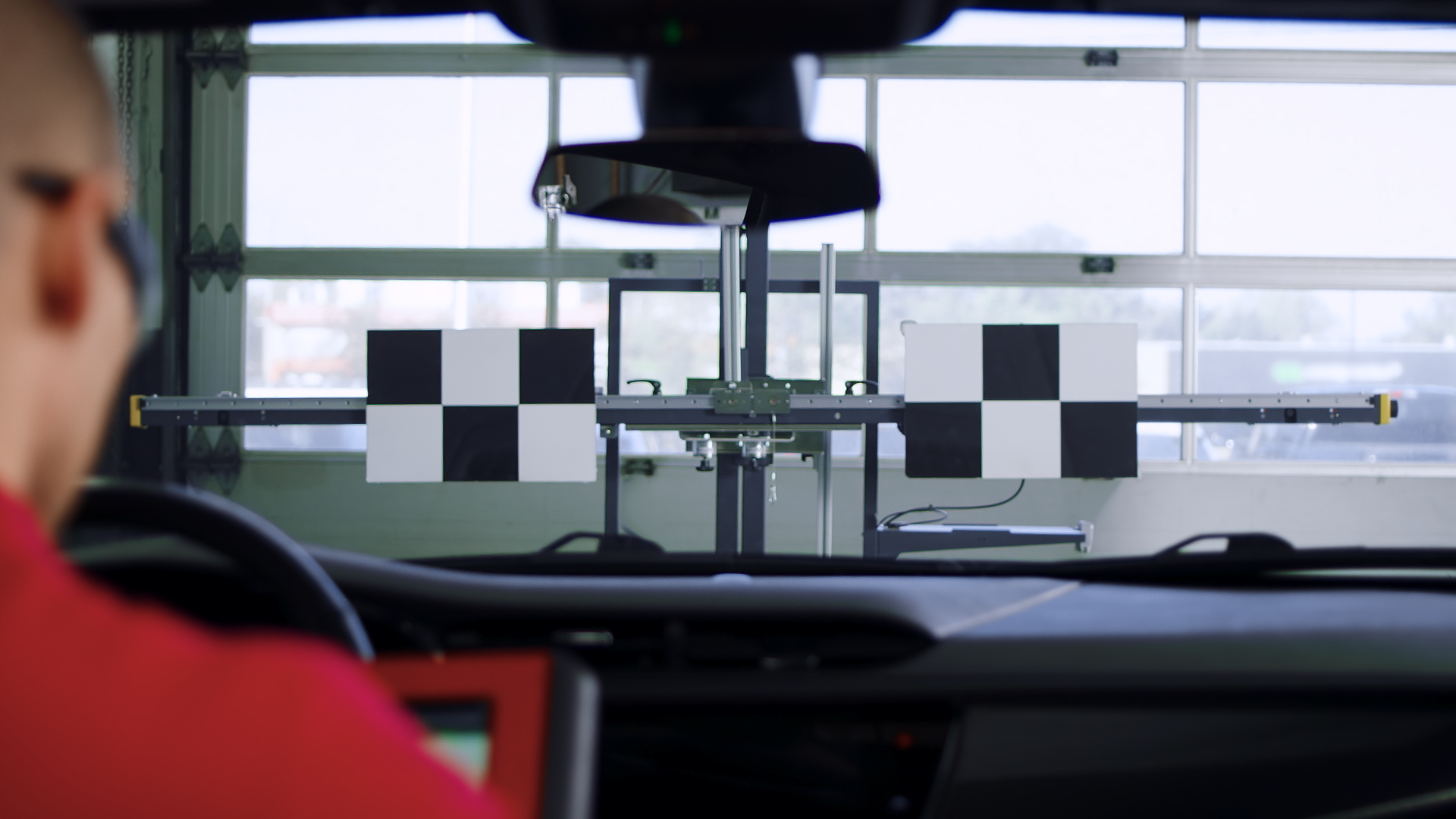 Technician in a car performing calibration of a car camera