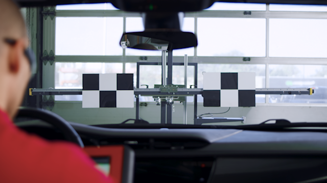 Technician in a car performing calibration of a car camera