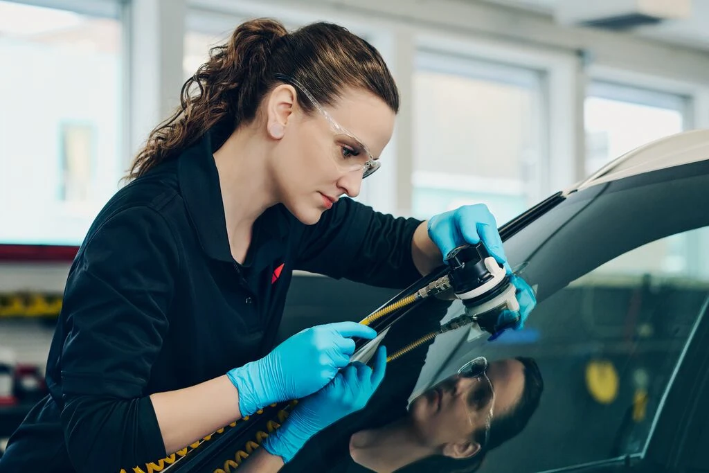 Vue de côté d'une femme applicant un outil sur un bris de vitre