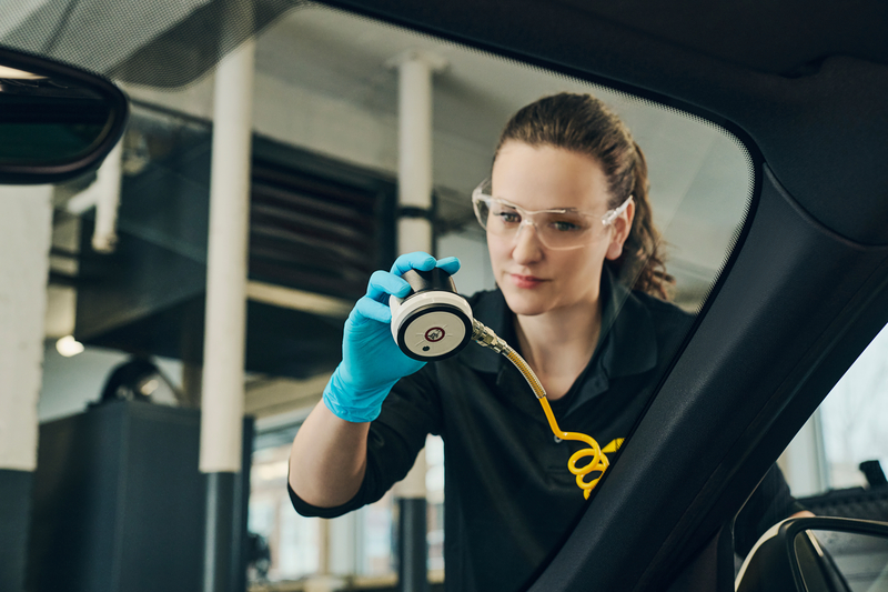 Technicienne placant un outil qui répare un bris de vitre