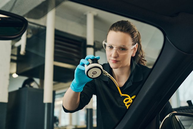 Technicienne placant un outil qui répare un bris de vitre
