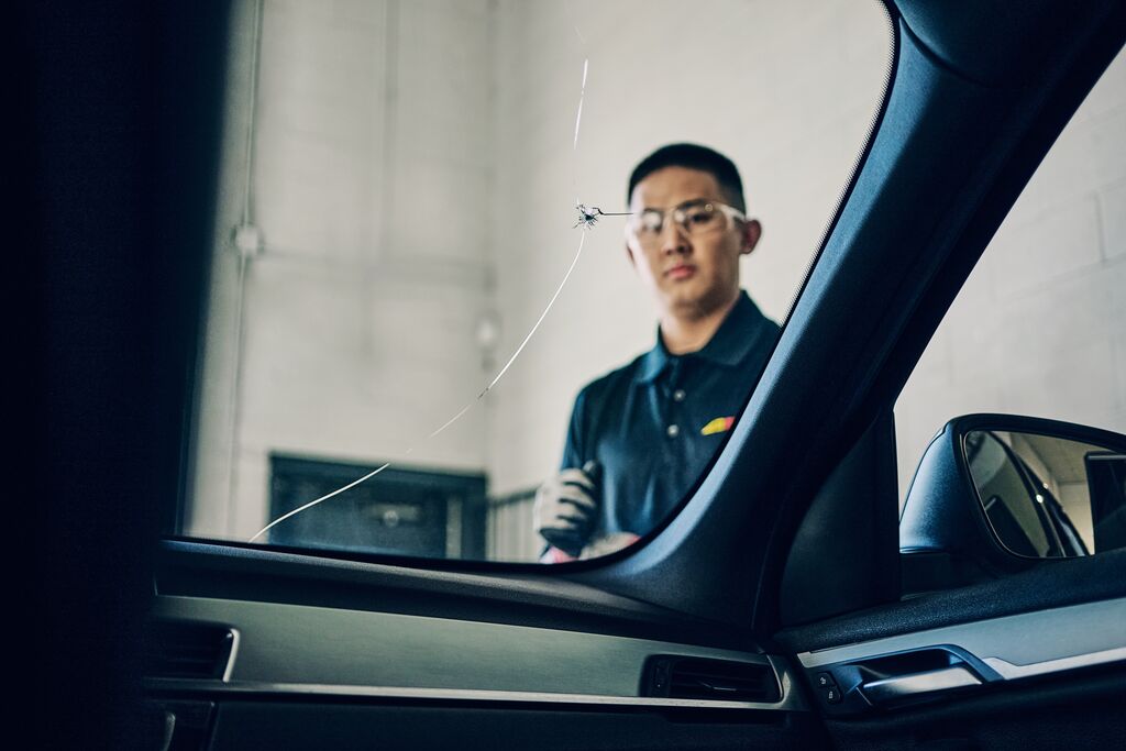 Crack in a windshield inspected by a technician