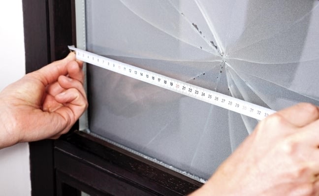 Mesure d'une vitre brisée avec un mètre