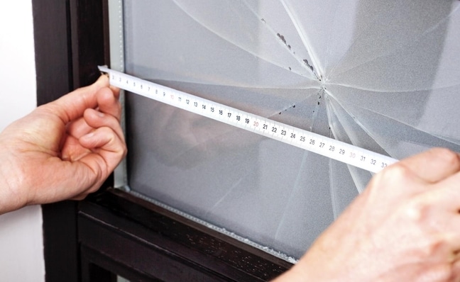 Measuring a broken window with a tape measure