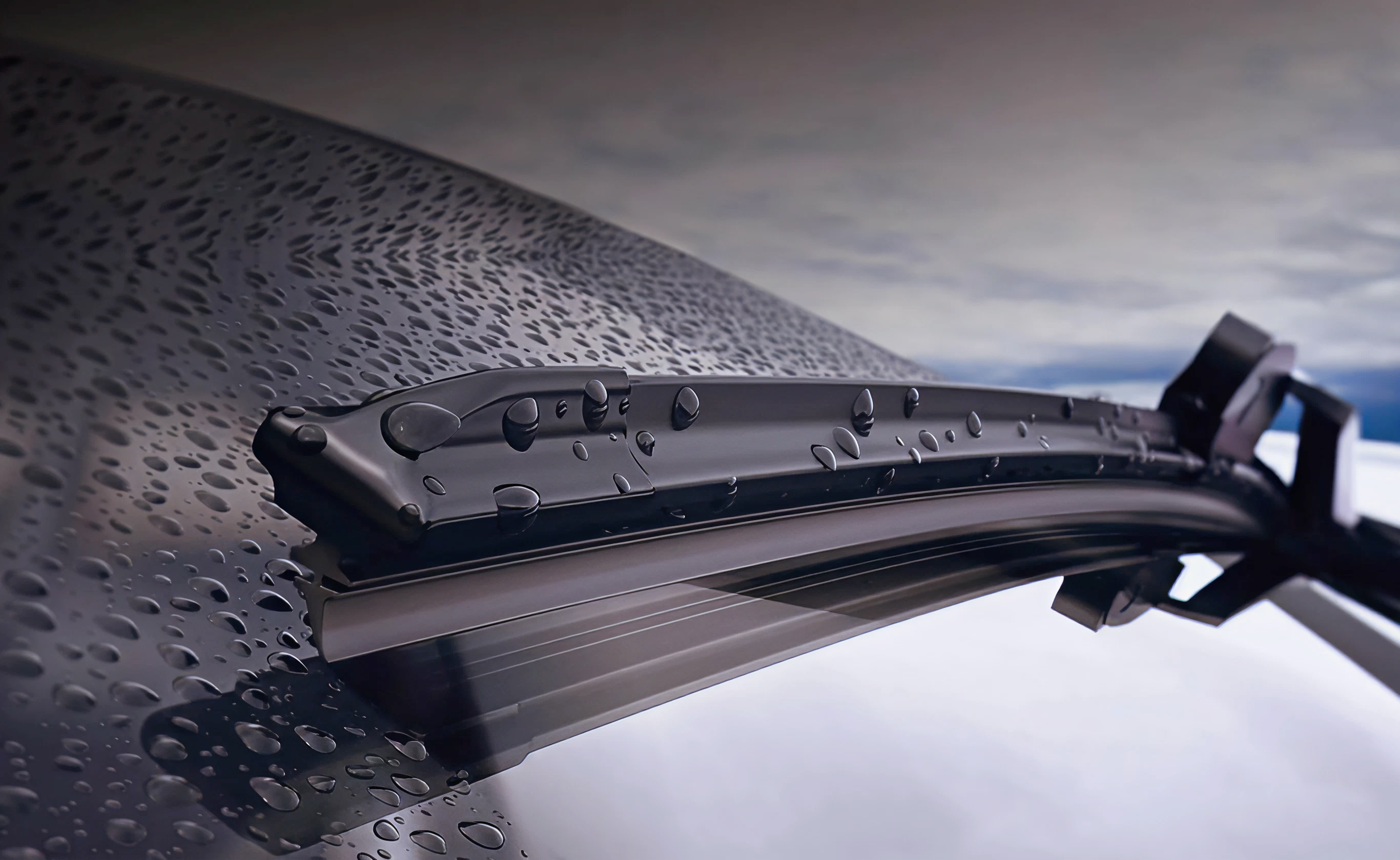 Windshield wipers in action, cleaning a wet windshield