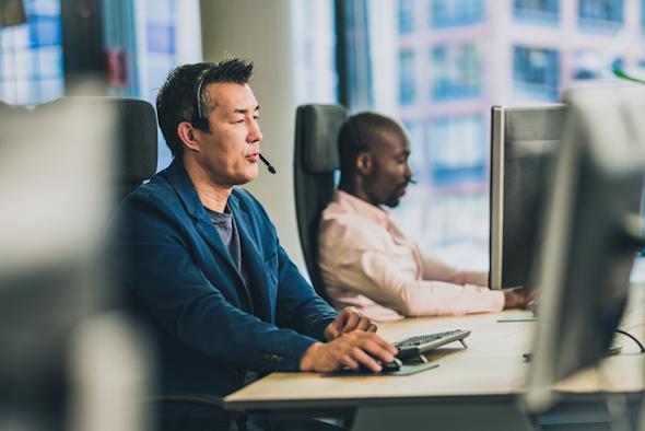 Two IT technicians providing remote IT support with Splashtop Enterprise.