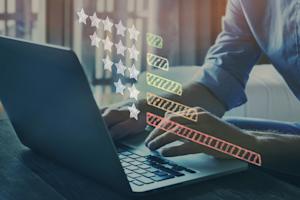 Person typing on a computer with star ratings imagery