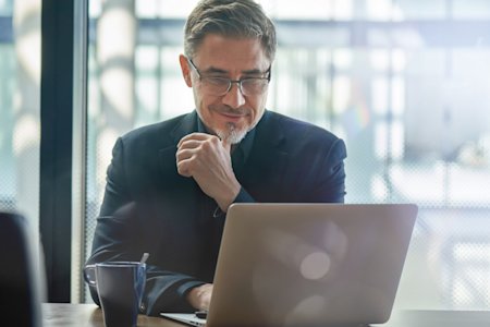 Executive reading information about Splashtop Business Access Pro on a laptop