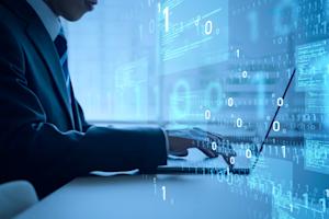 Business professional working on a laptop with digital code and cybersecurity graphics overlay.