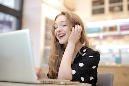 A young woman smiling while on her laptop