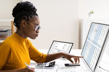 A woman working remotely and accessing QuickBooks remotely on her computer by using Splashtop.