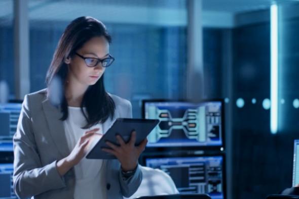 Female IT professional in data center reviewing MSP and security feeds