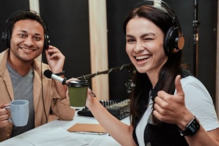 Two individuals with headphones on giving a thumbs up in approval of Splashtop's software on a podcast