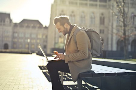 A man working outside on his laptop.