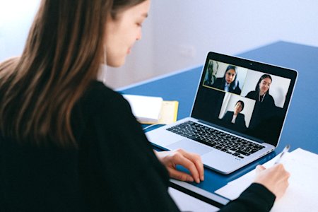 A businesswoman in a video call with her co-workers.