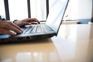 A person typing on a Windows PC laptop.