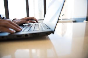 A person typing on a Windows PC laptop.
