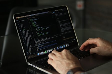 Hands typing on a laptop keyboard.