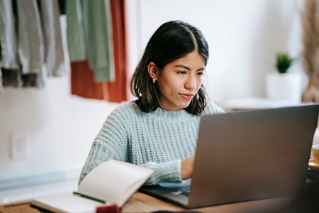 A woman using remote access software on her laptop, after switching to Splashtop from LogMeIn.