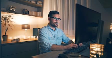 A man working on his computer at night.