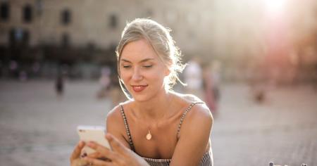 A woman outside using a smartphone.