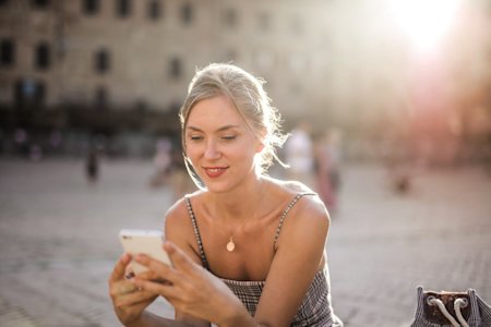 A woman outside using a smartphone.