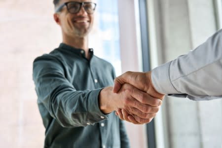 Two IT professionals shaking hands outdoors, symbolizing Splashtop's OEM and partner remote access opportunities