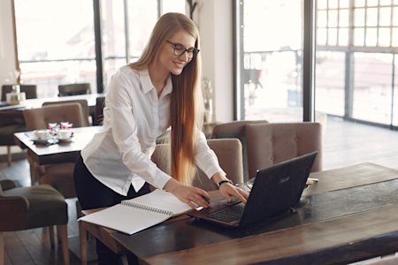 A woman working remotely in a cafe using her laptop.