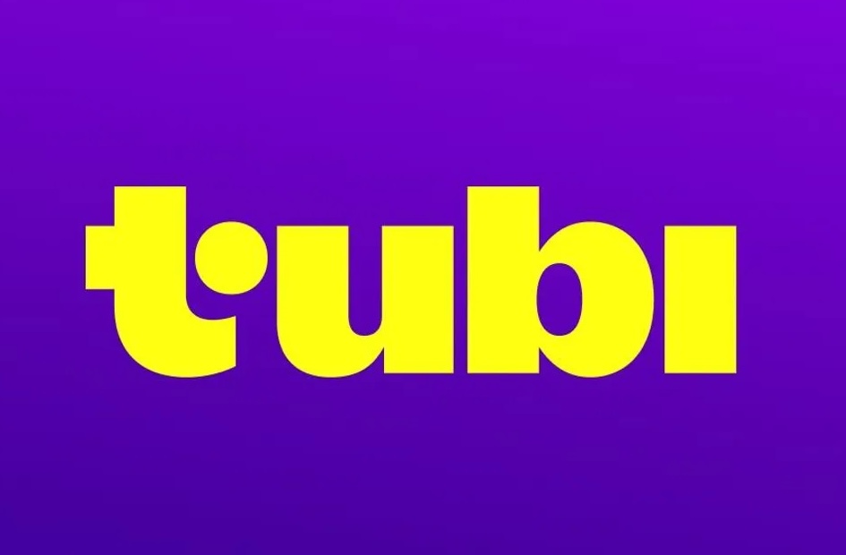 The image shows the Tubi logo with the word tubi in bold, yellow lowercase letters against a purple background.