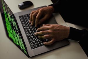 Hands typing on a laptop keyboard.