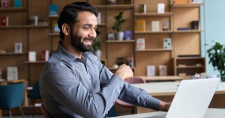 IT manager working in a Hybrid Office environment with a smile on their face