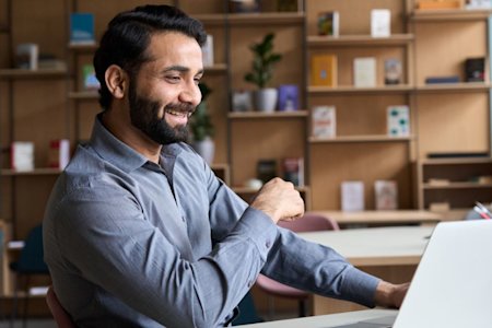 IT manager working in a Hybrid Office environment with a smile on their face