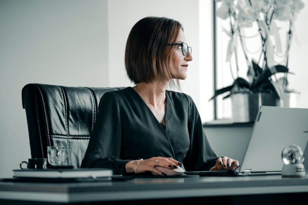 A woman working on a computer at her office desk.