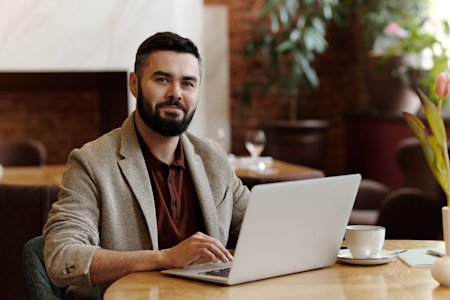 A smiling IT technician at his laptop.