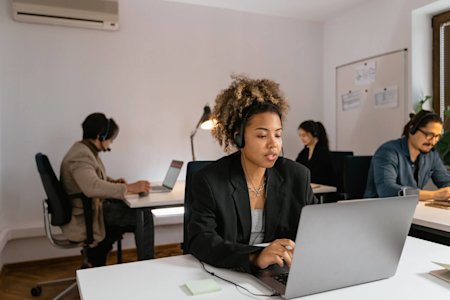 A woman in an office using remote maintenance software.