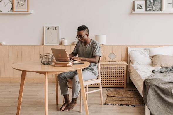 An IT worker working from home on a laptop.