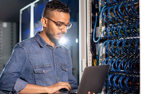 An IT professional reviewing data at a data center