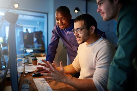 IT team collaborating on endpoint monitoring at a workstation, using Splashtop AEM.