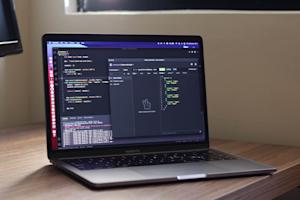 A Mac laptop displaying code for API connectivity on a wooden desktop.