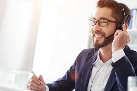 An IT tech smiling while providing remote support thanks to Splashtop SOS.